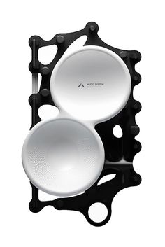 two white dishes sitting on top of each other in front of a black holder with holes