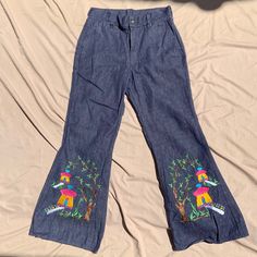 Woman's Pants Measurements: Waist - 32 inches around  Hip 7 inches down - 40 inches  Rise - 12 1/2 inches  Inseam to cuff - 28 1/2 inches Bell - 11 1/2 inches Total Length - 39 1/2 inches  Details: 1970s Indigo Denim Bell Bottoms With Embroidery  Seems to be unworn and unwashed Embroidered yellow houses with trees and flowers Made in india Amazing Condition! (Sold As Is) High Waist Embroidered Blue Pants, Blue Embroidered High Waist Pants, Embroidered Wide Leg Denim Blue Pants, Blue Embroidered Wide Leg Jeans, High Waist Embroidered Denim Blue Bottoms, Embroidered Blue Straight Leg Pants, Blue Embroidered Straight Leg Bottoms, Blue Embroidered Straight Leg Pants, Embroidered Dark Wash Mid-rise Bottoms