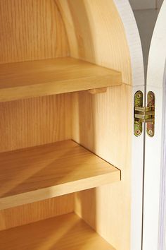 an open wooden door with shelves in front of it