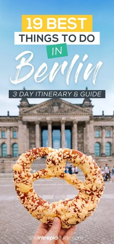 a person holding up a pretzel in front of a building with the words, 19 best things to do in berlin