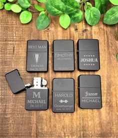 six personalized lighters are sitting on a wooden table next to some green leaves