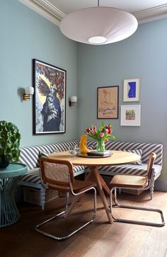 a living area with a couch, table and pictures on the wall above it's coffee table