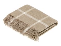 a tan and white plaid blanket with fringes on it's edges, against a white background