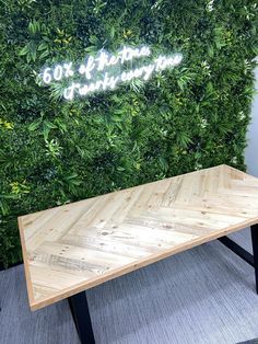 a wooden table sitting in front of a green wall with the words 60 % off