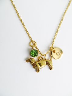 a gold necklace with two charms and a dog charm on it's link chain