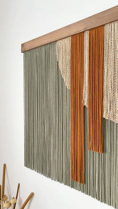 the wall hanging is made out of yarn and wood