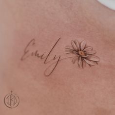 the back of a woman's stomach with a daisy tattoo on it