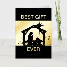 a black and gold christmas card with the words best gift ever written on it next to a potted plant