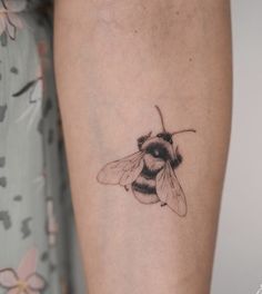 a small tattoo of a bee on the arm