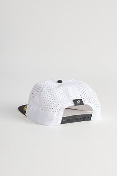 a white and black baseball cap on a white surface with the visor partially covering it's brim