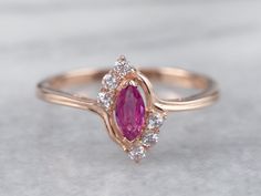 "This ruby ring is classic with a twist! The marquise cut of the ruby is flattering on the hand, with diamond accents that add lots of sparkle. Bypass style shoulders create a sense of movement and bring this ring to life! Metal: 14K Rose Gold Gem: Ruby .20 Carats Gem Measurements: 3.1 x 6 mm, Marquise Cut Accents: 6 White Sapphires totaling .15 Carats Ring Size: 8.25 Marks: \"14K China\" Stamped on the inside band SKU #: 8NU3KZX6 Each piece has been identified and graded by a Graduate Gemologis Ruby Ring Designs, Real Diamond Earrings, Gold Finger Rings, Gem Ruby, Ring Rosegold, Gold Plated Bangles, Coral Ring, Victorian Rings, Gold Earrings Designs