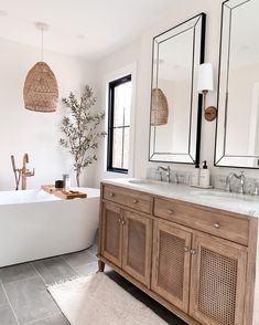 a bathroom with two sinks, mirrors and a bathtub in the middle of it