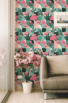 a living room with pink and green wallpaper, a gray chair and flowers on the floor