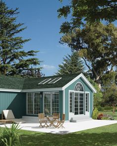 a small blue house sitting on top of a lush green field