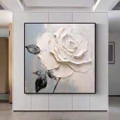 a large white rose painting hanging on the wall