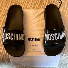 Black Slides W/ Logo On Front Brand New Black Logo Sandals For Summer, Black Designer Sandals With Logo, Designer Round Toe Sandals With Logo, Spring Round Toe Sandals With Logo, Designer Black Sandals With Rubber Sole, Moschino Shoes, Moschino Couture, Black Slides, Moschino