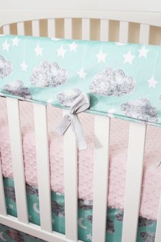 a baby crib with stars and clouds on it