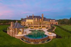 a large house with a pool in the front yard and an outdoor fireplace on the side