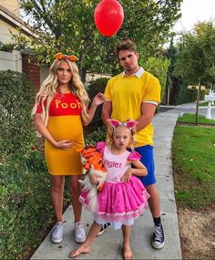 a man, woman and child are dressed up as winnie the pooh and tigger