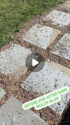 a sign that is on the ground in front of some grass and rocks with words below it