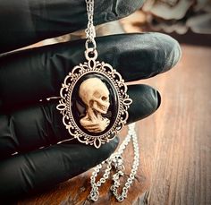 There is no better way to show your gothic style than with a unique Victorian inspired cameo necklace. The cameo is cast from an original sculpt by me, hand painted, and clear coated for durability. Pendant measures approx 27mm long and hangs from an 18" chain Ships USPS Ground Gothic Hand-cast Halloween Necklaces, Steampunk Skull Jewelry Gift, Gothic Nickel-free Necklaces, Nickel-free Gothic Necklaces For Collectors, Nickel Free Gothic Necklaces For Collectors, Gothic Hand Cast Collectible Necklaces, Hand Cast Skull Necklace As Gift, Hand Cast Skull Necklace For Gift, Gothic Cameo Necklaces For Gifts