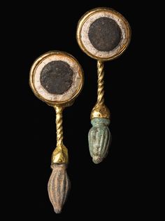 two gold and stone candlesticks, possibly from the late roman period with shells on them