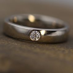 a close up of a wedding ring with a diamond