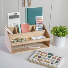 a desk with a phone, notebooks and other office supplies on top of it