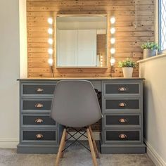 a chair sits in front of a vanity with lights on it and a mirror above it