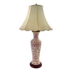 a pink and white lamp with a beige shade on the top is sitting in front of a white background