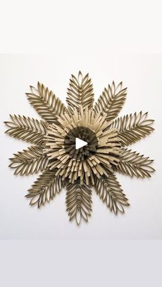 a gold metal snowflake on a white wall