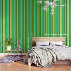 a bedroom with green striped wallpaper and a bed in the foreground is a chandelier