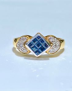 "Gorgeous square cut sapphire and round cut diamond cocktail ring for women. This ring is cleverly molded with a mirrored gold floral design. The \"mirroring\" effect is exaggerated with the bright baguette cut diamonds. Message me for a certificate with your order. ✔ Gold Karat: 18K ✔ Sapphire Weight: 0.50 carats (9 stones) ✔ Sapphire Origin: Thailand ✔ Sapphire Cut: Square cut, illusion ✔ Diamond Weight: 0.15 carats total ✔ Diamond Color: H-I ✔ Diamond Clarity: SI1 ✔ Diamond Cut: Round ✔ Ring Princess Cut Sapphire Ring, Blue Sapphire Ring, Gold And Blue, Diamond Cocktail Rings, Square Earrings Studs, Baguette Cut Diamond, Round Rings, Emerald Earrings, Square Earrings