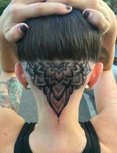 a woman's neck with a tattoo design on her face and behind her head