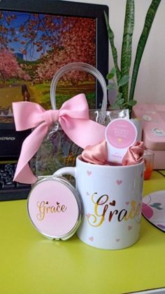 there is a small cup with some pink bows on it and two coasters next to it