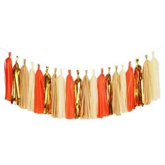 an orange and gold tasselled garland hanging from a string