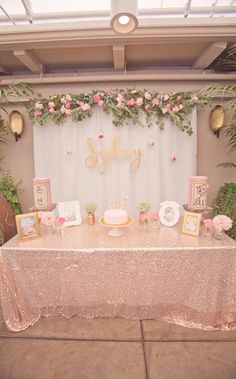 a table topped with a cake covered in pink flowers