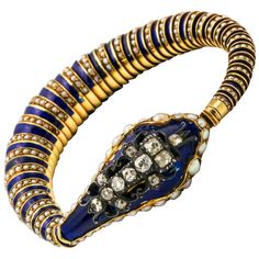 Designed as serpent, the gold head inset with split pearls, applied with blue enamel, surmounted with an openworks silver motif set with twelve old mine-cut diamonds, the body composed of nesting hemispherical links applied with alternating blue enamel and seed pearls, internal circumference 6 1/4 inches. Antique Bracelets, Snake Jewelry, Snake Bracelet, Art Nouveau Design, Enamel Bracelet, Pearl Diamond, Nature Bracelets, Vintage Bracelets, Natural Pearls