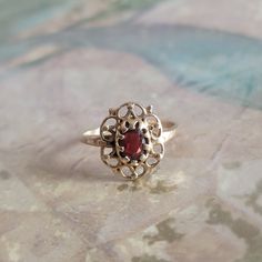 This is a vintage, 14 Karat,  yellow gold and garnet, ring. It has stamped 14 K and has tested positive for 14 karat gold. All sales are final.  This ring is a between a size 3.5 and 3.75 (please see the images) and can be sized. Please note, sizing is up to the buyer. I do not provide this service. If you have a wish list or are looking for something specific, please ask. I may have exactly what you are looking for.  As always please convo me with any questions or concerns regarding this item or with any international shipping questions. Unfortunately I do not accept returns or grant refunds. All shipping fees include handling fees. If you would like to combine shipping costs for more than one item, I would be happy to do so if you convo me before purchase.  Purchasing my item means you h Vintage Gold Cluster Ring With Gemstones, Gold Garnet Birthstone Ring, Antique Red Signet Ring In 14k Gold, Antique Red 14k Gold Signet Ring, Vintage 14k Gold Cluster Ring Hallmarked, Antique Ruby Ring Hallmarked, Vintage Ruby Gold Rings, Garnet Rings Stamped 14k For Anniversary, Anniversary Garnet Rings Stamped 14k