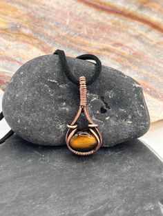 Elegant and minimalist hand wire wrapped Tigers Eye pendant wrapped in bare copper wire both round wire and square wire. Pendant has been oxidized and hand polished for the beautiful antique look. Pendant comes on a black adjustable cord necklace. ~ Healing with Tiger's Eye ~ ♥ Protection ♥ Clear thinking ♥ Personal empowerment ♥ Integrity ♥ Willpower ♥ Practicality ♥ Grounding ♥ Power ♥ Courage ♥ Grace A stone of protection, Tiger Eye may also bring good luck to the wearer.  It has the power to Minimalist Wire Wrapped Copper Jewelry, Minimalist Copper Wire Wrapped Jewelry, Tigers Eye Jewelry, Suede Necklace, Bijoux Fil Aluminium, Personal Empowerment, Tiger Eye Jewelry, Wire Wrap Pendant, Clear Thinking