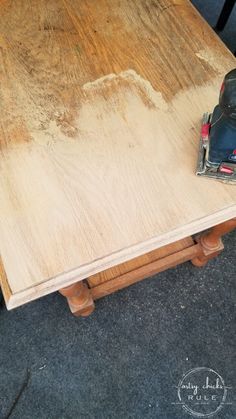 a table with a sanding mitt on top of it next to a power drill