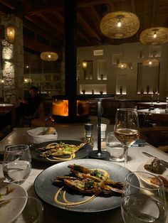 a table topped with plates of food and wine glasses