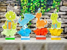 some paper cutouts are sitting on a table with flowers and plants in the background