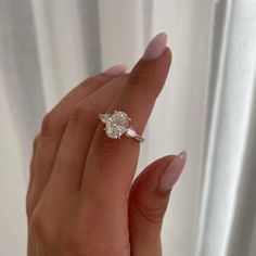 a woman's hand holding an engagement ring