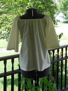 "Made to order This shirt is made from 100% cotton. It has elastic at the neckline and 3/4 length sleeves. Can be worn on or off the shoulder. The 3/4 length sleeve on this shirt makes it cooler for summer festival and faire wear! Available in Bleached White Muslin or Natural Muslin. (Also available different colors of 100% cotton and in a poly cotton blend - message me if you have a color request ). These are all good quality lightweight shirting fabrics. This is a loose fit shirt. Sized to fit Peasant Cotton Blouse For Gatherings, Peasant Style Cotton Blouse For Gatherings, Cotton Peasant Top For Gatherings, White Cotton Blouse For Gatherings, Cotton Peasant Blouse For Daywear, Summer Cotton Blouse For Gatherings, Fitted Cotton Tops For Gatherings, Fitted Cotton Peasant Top, Fitted Cotton Peasant Top Cottagecore Style