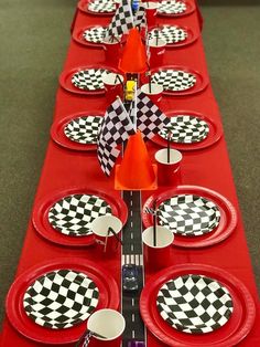 a long red table with black and white checkered plates