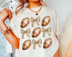 a woman wearing a t - shirt with an image of footballs and bows on it