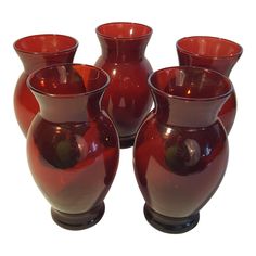 four red vases sitting next to each other