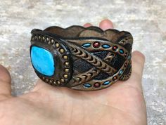 "\"Past and future secrets\" is a tooled leather bracelet with bright blue Arizona turquoise cabochon. Nice piece of jewelry for a stylish man. The bracelet is 1 1/2\" (~4cm) in widest place and fits up to ~8\" (~20cm) wrist. This particular bracelet was MADE TO ORDER. If you would like to get something similar (or something different) - just place a custom order and I will arrange something for you. Please bear in mind I can't repeat the same precise design since each item I make is unique. Thu Turquoise Hand Tooled Leather Cuff Bracelet, Turquoise Leather Cuff Bracelet Hand Tooled, Southwestern Leather Bracelet As Gift, Southwestern Leather Bracelet As A Gift, Southwestern Style Leather Bracelets As Gift, Southwestern Style Leather Bracelet As Gift, Handmade Western Cuff Bracelet As Gift, Handmade Western Style Cuff Bracelet, Western Leather Cuff Bracelet As Gift