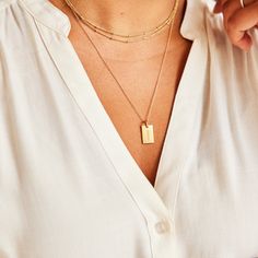 Our best selling tag now holds the name that matters most! This classic piece is beautiful on its own, but also pairs perfectly with our birthstone charms, and circle and heart tags. vermeil is a sterling silver base with 100+ mls of 24k gold mini dog tag is 5/8″ L x 1/3″ W "mama" engraved on front, no back engraving, ready to ship within 24 hours hangs on 18"chain *model is wearing the mama dog tag on a 24" chain layered with our 30" satellite chain Mama Jewelry, Tiny Tags, Mini Dog, Mama Necklace, Mini Dogs, Heart Tag, Nameplate Necklace, Circle Necklace, Birthstone Charms